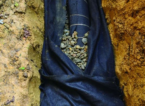 Filter fabric lining a French drain trench