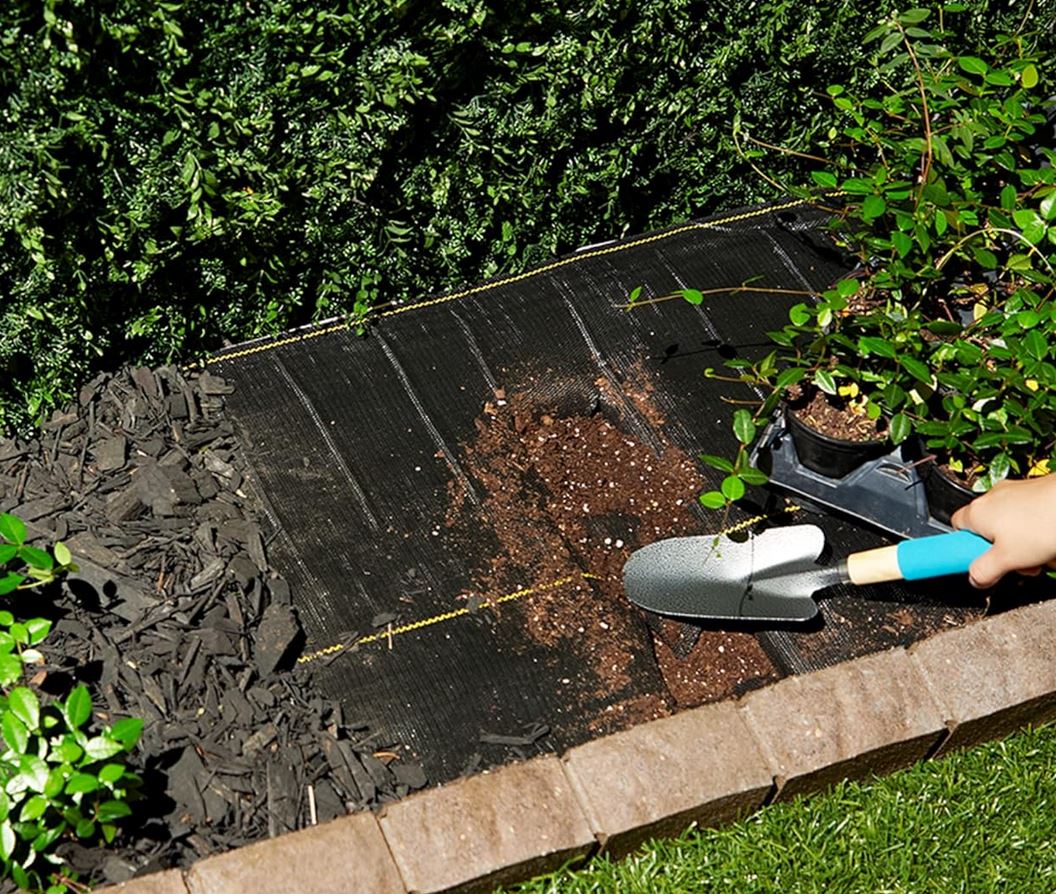 Installing DeWitt weed barrier fabric under mulch